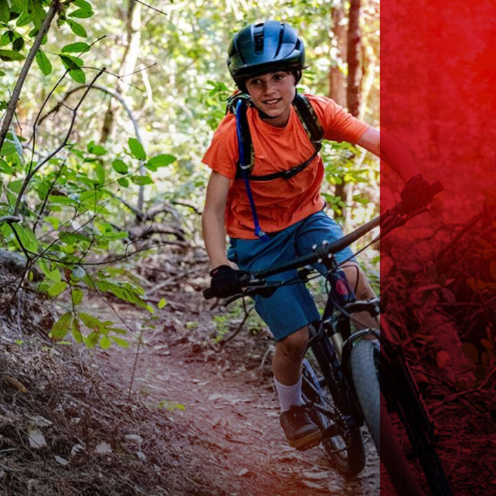 kid riding a mountain bike  with a red graphic treatment