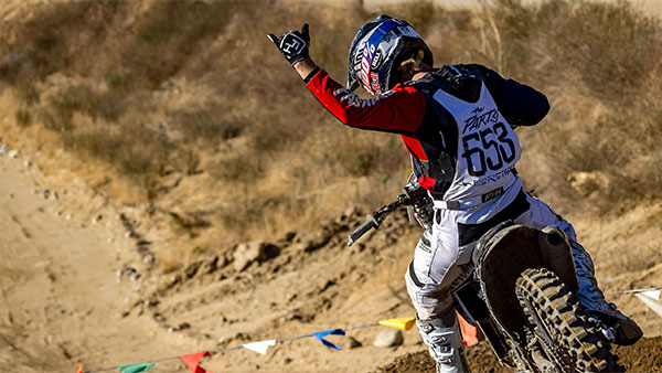 Rider giving the hang loose sign as he rides away down the track