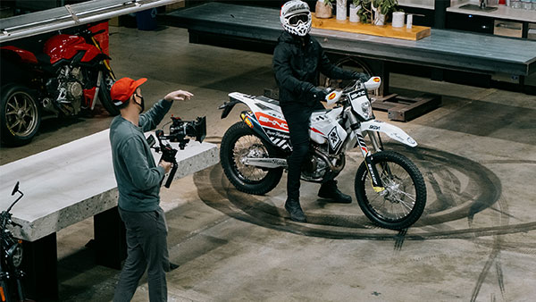 Behind the scenes image of photographer giving direction to rider on a motorcycle