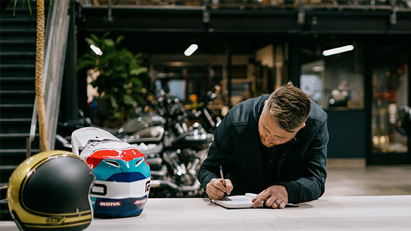 Roland sands drawing in a notebook on a table