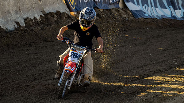 Kid on a small bike racing around the track