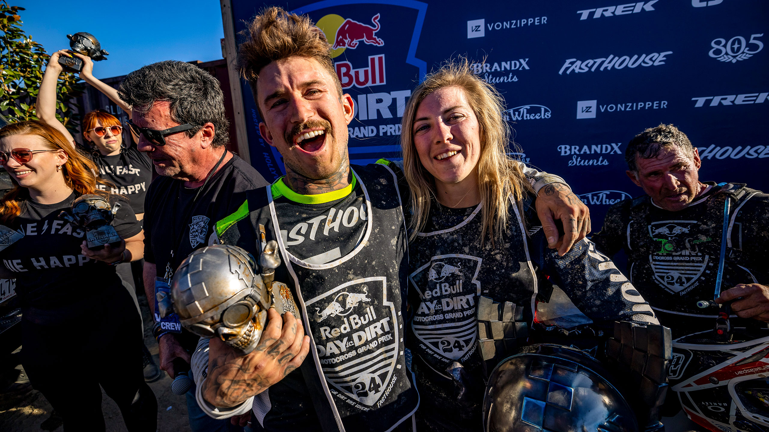 Seth Brisson and Vicki Golden holding trophies and celebrating at the podium