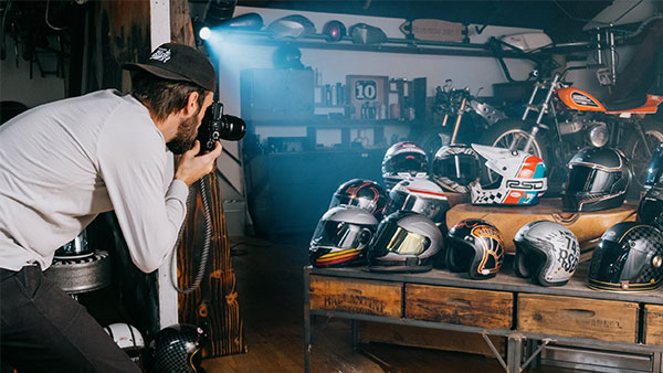 Behind the scenes image of photographer taking picture of a group of helmets
